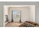 Bonus room with neutral carpet, large window, soft seating, and neutral decor at 71 Pulaski Ave, Hampton, GA 30228