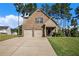 Charming brick home with a two-car garage, manicured lawn, and mature trees, offering classic curb appeal at 71 Pulaski Ave, Hampton, GA 30228