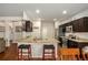 Spacious kitchen with granite island and barstool seating, stainless steel appliances, and access to adjacent living spaces at 71 Pulaski Ave, Hampton, GA 30228
