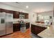 Bright kitchen with stainless steel appliances, granite countertops, wood cabinets, and a cozy dining area with natural light at 71 Pulaski Ave, Hampton, GA 30228
