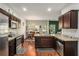 Well-equipped kitchen with stainless steel appliances, dark wood cabinets, granite countertops, and eat-in dining area at 71 Pulaski Ave, Hampton, GA 30228