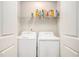 Convenient laundry room with white washer and dryer, plus wire shelving for storage at 71 Pulaski Ave, Hampton, GA 30228