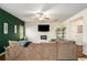 Comfortable living room featuring plush sectional sofa, ceiling fan, and a modern electric fireplace below the mounted TV at 71 Pulaski Ave, Hampton, GA 30228