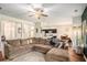 Open-concept living room flows into a dining area and kitchen, featuring a plush sectional and hardwood floors at 71 Pulaski Ave, Hampton, GA 30228