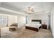 Bright main bedroom with carpet, tray ceiling, large windows, a cozy chair, and ample space at 71 Pulaski Ave, Hampton, GA 30228