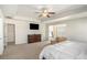 Serene main bedroom featuring cozy seating area, large dresser, mounted tv, and neutral tones at 71 Pulaski Ave, Hampton, GA 30228