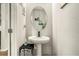 Stylish powder room features pedestal sink, modern fixtures, decorative mirror, and neutral decor at 71 Pulaski Ave, Hampton, GA 30228