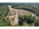 An aerial view showing various lots with new construction homes being built within a heavily wooded community at 128 Prescott Manor Dr, Canton, GA 30115