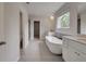 Bathroom with freestanding tub, double vanity, and gray tile floor at 165 Haverling Pass, Hampton, GA 30228