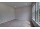 Bright bedroom featuring neutral carpet, recessed lighting, and a large window at 165 Haverling Pass, Hampton, GA 30228