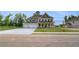 Elegant two-story home showcasing a large driveway, inviting entrance, and charming landscaping at 165 Haverling Pass, Hampton, GA 30228