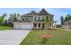 Stunning two-story home featuring a spacious three-car garage, manicured lawn, and a classic design at 165 Haverling Pass, Hampton, GA 30228