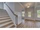 Light filled foyer with hardwood floors, view of the staircase, and door to the outside at 165 Haverling Pass, Hampton, GA 30228