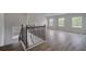 Upstairs hallway with wood flooring and a wood/metal staircase and plenty of natural light at 165 Haverling Pass, Hampton, GA 30228