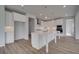 An open kitchen features all white cabinetry, an island with wood-look floors at 165 Haverling Pass, Hampton, GA 30228