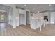 An open kitchen features all white cabinetry, an island and wood-look floors at 165 Haverling Pass, Hampton, GA 30228