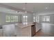 An open living room and kitchen features an island, and lots of windows at 165 Haverling Pass, Hampton, GA 30228