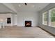 A living room with a fireplace adjacent to an open kitchen with wood look floors at 165 Haverling Pass, Hampton, GA 30228