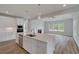 An open living room and kitchen features an island, fireplace and stainless appliances at 165 Haverling Pass, Hampton, GA 30228