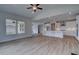 A living room with fireplace adjacent to an open kitchen with wood look floors and large windows at 165 Haverling Pass, Hampton, GA 30228