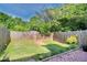 Fenced backyard features a lush lawn, mature trees, and a charming brick patio area for outdoor enjoyment at 315 Towergate Pl, Atlanta, GA 30350