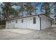 Exterior view of a white brick home with a concrete patio and new wooden railings at 3893 Bonnie Se Ln, Atlanta, GA 30354