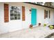 Up-close view of the front exterior with a bright blue door, wood shutters, and potted flowers at 3893 Bonnie Se Ln, Atlanta, GA 30354