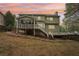 The backyard has a screened porch, a deck, and stairs leading to a sloped yard with retaining wall at 2118 Township Dr, Woodstock, GA 30189