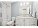 Well-lit bathroom with white vanity, marble countertop, and shower-tub combination at 2118 Township Dr, Woodstock, GA 30189
