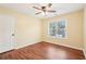 Cozy bedroom with wood-look floors, ceiling fan, and a window offering natural light at 2118 Township Dr, Woodstock, GA 30189