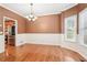 Elegant dining room featuring dark walls with white trim, hardwood floors, and modern chandelier at 2118 Township Dr, Woodstock, GA 30189