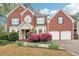 Charming two-story brick home with landscaped yard, blooming flowers and a two-car garage at 2118 Township Dr, Woodstock, GA 30189