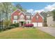 Beautiful two-story brick home with well-manicured lawn, mature trees and attached two-car garage at 2118 Township Dr, Woodstock, GA 30189
