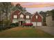 Classic brick home featuring manicured lawn, mature trees, and a two-car garage at 2118 Township Dr, Woodstock, GA 30189
