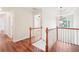 Upstairs hallway with hardwood floors and natural light from the windows at 2118 Township Dr, Woodstock, GA 30189
