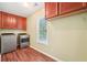 Functional laundry room with wooden cabinets, modern washer and dryer, and natural light at 2118 Township Dr, Woodstock, GA 30189