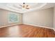 Bright main bedroom features a tray ceiling, hardwood floors, and a large window at 2118 Township Dr, Woodstock, GA 30189