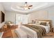Staged main bedroom boasts tray ceilings, a ceiling fan, and an ensuite bathroom at 2118 Township Dr, Woodstock, GA 30189