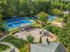 Aerial view of community tennis courts and playground surrounded by lush trees at 2118 Township Dr, Woodstock, GA 30189