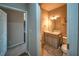 A partial view of a bathroom with a sink, toilet, and cabinet in neutral tones next to a hallway entrance at 2234 Oak Falls Ln, Buford, GA 30519