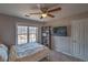 Cozy bedroom with ceiling fan, large window, and a bookshelf, creating a relaxing atmosphere at 2234 Oak Falls Ln, Buford, GA 30519