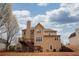 Back of house with wooden deck, spacious yard, and stairs leading to the lower level at 2234 Oak Falls Ln, Buford, GA 30519