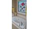 A bathroom features a tub, a stained glass window, and light colored tile at 3715 Millers Pond Way, Snellville, GA 30039