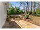 Concrete patio and retaining wall define the backyard area with minimal landscaping at 3844 Rena Se Ln, Smyrna, GA 30082