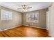 A cozy bedroom featuring hardwood floors, a ceiling fan, and natural light from two windows at 3844 Rena Se Ln, Smyrna, GA 30082