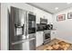 Modern kitchen with stainless steel fridge, gas range, white cabinetry, and black backsplash at 400 W Peachtree Nw St # 2011, Atlanta, GA 30308