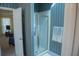 Cozy bathroom area with glass enclosed shower, towel rack, and blue striped wallpaper at 4288 Wyndham Park Cir, Decatur, GA 30034