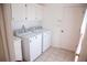 Clean laundry room with white cabinets, a sink, and modern washer and dryer units at 4288 Wyndham Park Cir, Decatur, GA 30034