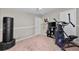 A well-lit basement featuring fitness equipment, a mounted TV, and ample space for activities at 515 Quinn Dr, Woodstock, GA 30188