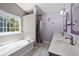 Well-lit bathroom with double sinks, soaking tub, tiled shower, and modern fixtures at 515 Quinn Dr, Woodstock, GA 30188
